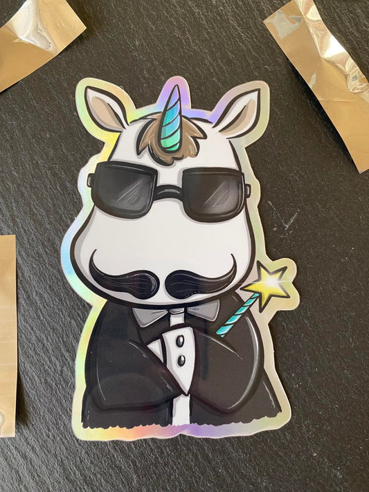 A holographic sticker of a cartoon unicorn wearing sunglasses and a tuxedo, with a wand and star in its hooves.